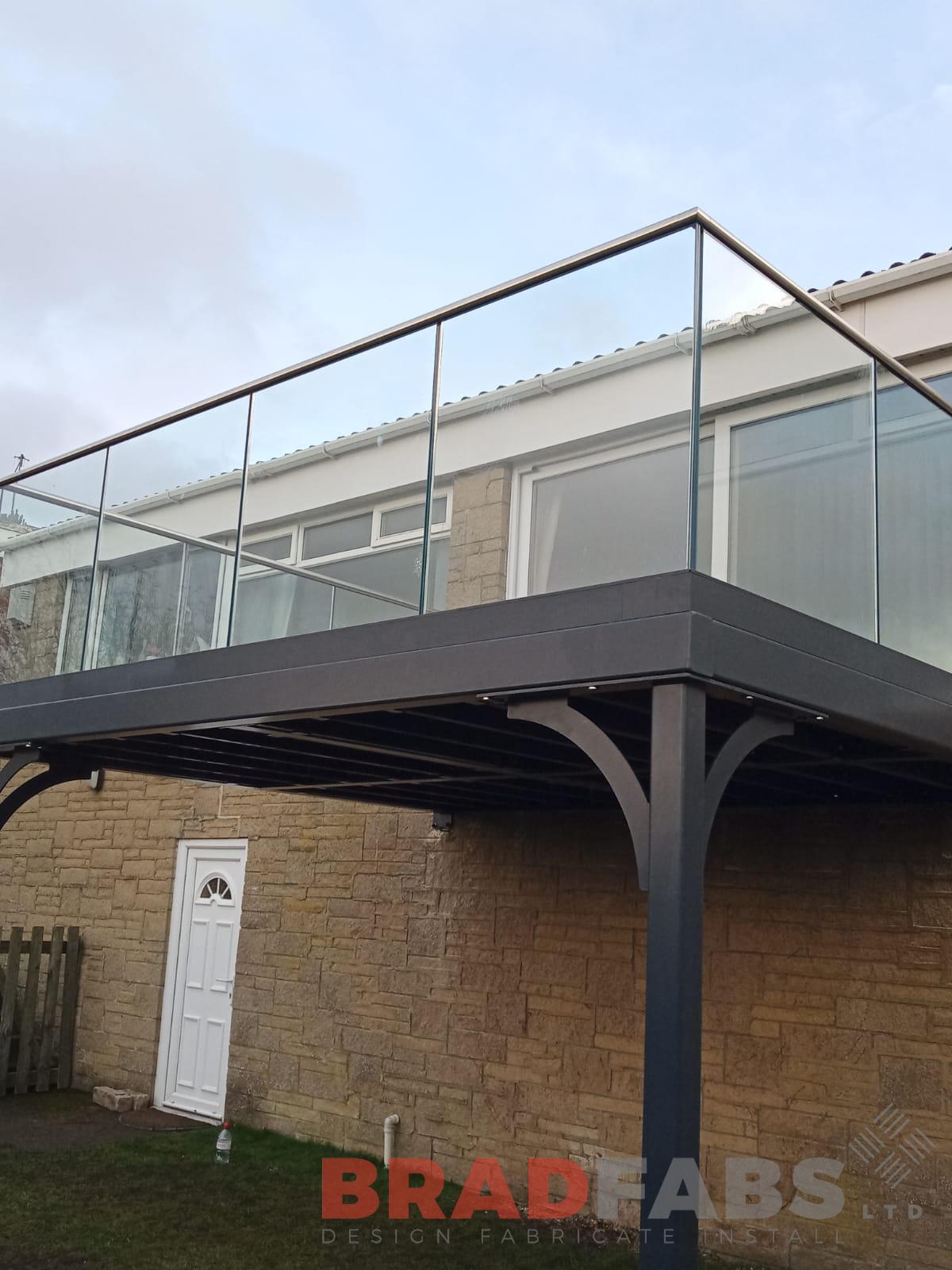 large steel balcony with infinity glass balustrade and stainless steel top rail by Bradfabs 