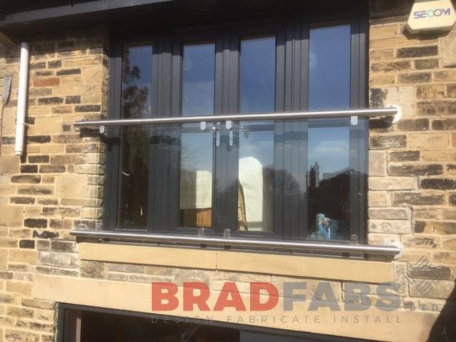 Modern Juliette balcony by Bradfabs with glass balustrade and stainless steel top and bottom rail. 
