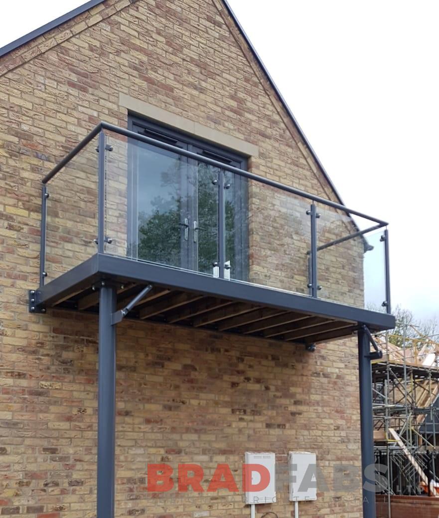 Bespoke design by Bradfabs, mild steel balcony, galvanised, powder coated with glass infill panels and composite decked flooring 