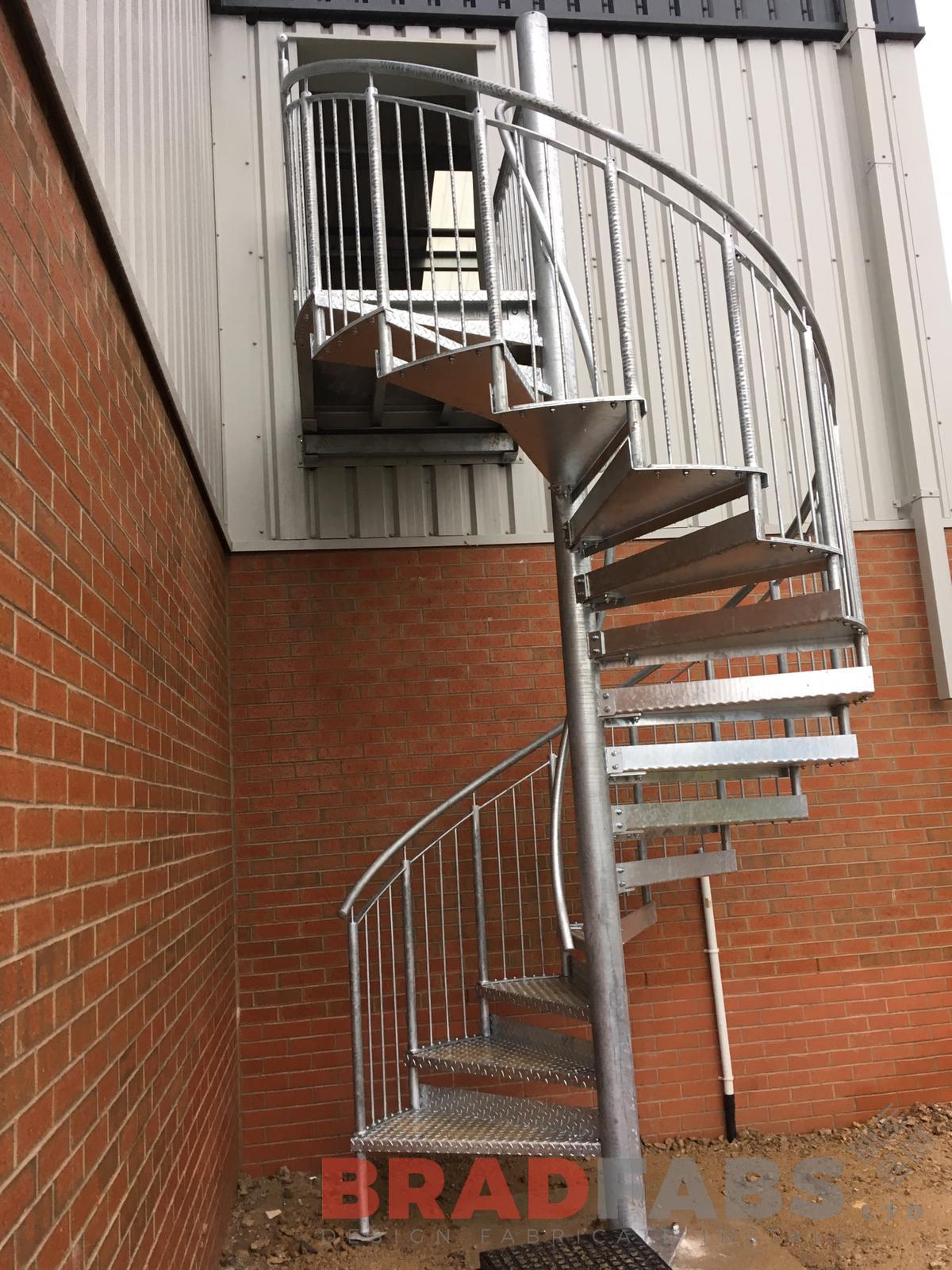 Bespoke spiral fire exit stair by Bradfabs Ltd, mild steel and galvanised, vertical bar balustrade and tubular toprail, complete with durbar treads 