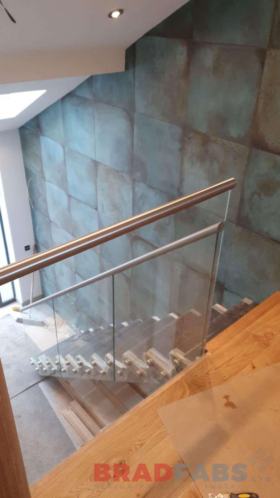 mild steel staircase with hidden stringer, oak treads and face fixed glass with stainless steel handrail by Bradfabs Ltd 